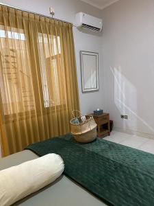 a room with a bed with a basket on it at Villa Magnifica by REQhome in Ciater-hilir