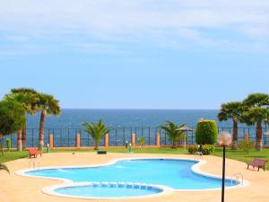 a swimming pool with the ocean in the background at Aguamarina, las Calitas, frente al mar in Orihuela Costa