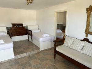 Pokój z 2 łóżkami, kanapą i lustrem w obiekcie Gioia’s view w mieście Loutra