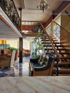 a living room with a couch and a staircase at Hotel Izvora in Ruse