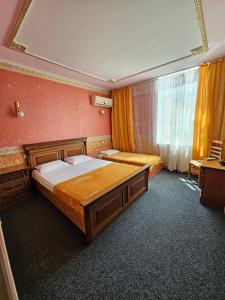 um quarto com uma cama grande e uma janela em Hotel Izvora em Ruse