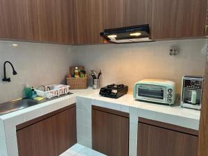 a kitchen with a sink and a microwave on a counter at Villa Magnifica by REQhome in Ciater-hilir +11 photos
