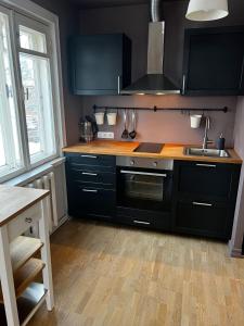 a kitchen with black cabinets and a sink at Videviku Apartments in Tallinn