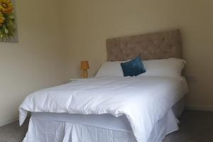 um quarto com uma cama branca e uma almofada azul em 3 bedroom house close to lough sheelin em Cavan