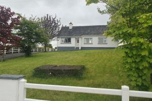 a white house with a white fence and a yard at 3 bedroom house close to lough sheelin in Cavan