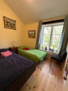 1 dormitorio con 2 camas y ventana en Bed&Breakfast in nature 12 min from city free bikes en Estocolmo