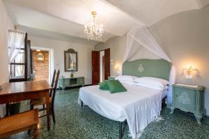 a bedroom with a bed and a desk and a piano at Piemonte Country House in Agliano Terme +24 photos