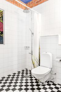 a bathroom with a toilet sitting on a checkered floor at Bed&Breakfast in nature 12 min from city free bikes in Stockholm