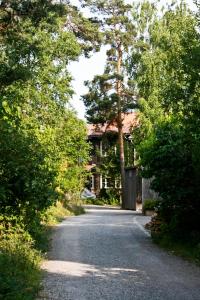 Bed&Breakfast in nature 12 min from city free bikes في ستوكهولم: طريق يؤدي إلى منزل به سياج