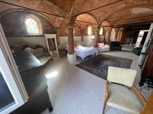 Habitación con cama y sillas en un edificio en B&B Antica cascina en Boretto