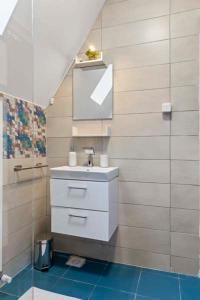 ein Bad mit einem Waschbecken und einem Spiegel in der Unterkunft Pensiunea Podul Simonului in Bran
