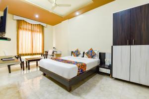 a bedroom with a king sized bed and a desk at FabHotel Bikaner Heritage in Jaipur