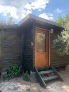 a small cabin with a wooden door and stairs at Pina bungalov restaurant in Ayvacık