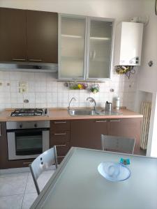 a kitchen with a sink and a table with chairs at bellavista civico 100 in Pescara