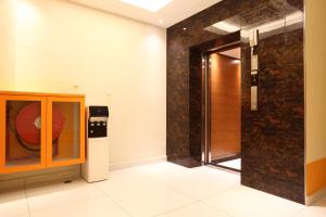 een badkamer met een glazen deur en een wasmachine bij Yee Hotel Permas in Johor Bahru