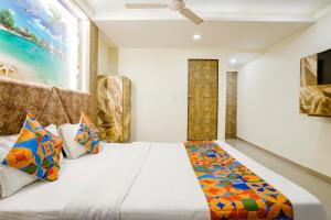 FabExpress Apollo I في أحمد آباد: غرفة نوم مع سرير كبير مع وسائد ملونة