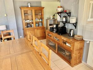 a kitchen with a wooden table and a wooden cabinet at Maison charmante à Saint-Géry avec piscine partagée in Saint-Géry