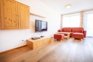 Una sala de estar con un sofá y un televisor. en Ferienwohnung Hochkrimml 19 __1-4, en Königsleiten