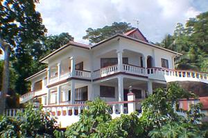 a white house with a balcony on top of it at Studio with sea view furnished terrace and wifi at Mahe in Mahe