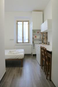 a kitchen with a table and a bed in a room at Le Residenze Della Poetessa in Corsico