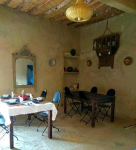 ein Esszimmer mit einem Tisch und Stühlen in der Unterkunft Dar Oasis Moringa in Merzane