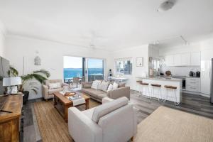a living room with a couch and a kitchen at Bayview Towers 10 in Nelson Bay