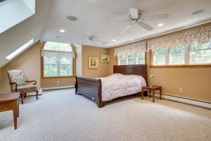 Un dormitorio con una cama y una silla y ventanas. en half Mi to Beach Stunning Home with Deck in Falmouth, en Falmouth