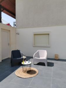 Rougemont的住宿－Studio au calme avec terrasse，客厅配有两把椅子和一张桌子