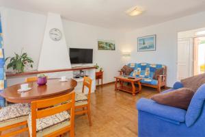 uma sala de estar com um sofá azul e uma mesa em Villa Lidia em Cala Galdana