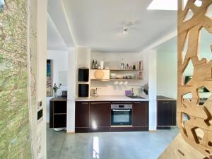 uma cozinha com paredes brancas e armários castanhos em Loft mit Dachterrasse em Bernau am Chiemsee