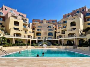 a swimming pool in front of a large apartment building at Spacious Luxurious Apartment with Seaview in Mellieħa