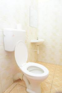 a bathroom with a white toilet and a sink at Elegant studio apartment in Kitengela 