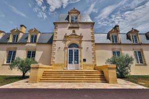 ein großes Gebäude mit Treppen davor in der Unterkunft Domaine Grand Piquecaillou - L'appartement Saint Emilion in Saint-Maixant