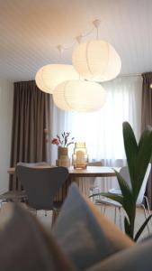 a dining room with a table and chairs and lights at Lovely villa at the foot of the Funen Alps in Fåborg