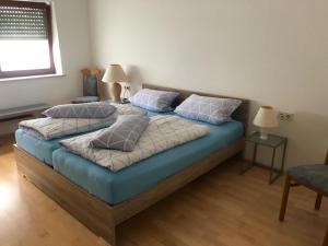 1 Schlafzimmer mit 2 Betten mit blauer Bettwäsche und Kissen in der Unterkunft Haus Aigner in Piding