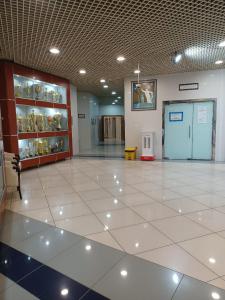 a large room with a white tile floor and shelves of vases at Al Jazira Club Hotel in Abu Dhabi