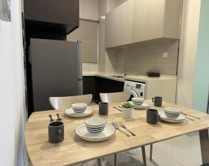 a kitchen with a wooden table with dishes on it at Country Garden Bay Point 2BR by Hauz Cinta @Danga Bay in Johor Bahru