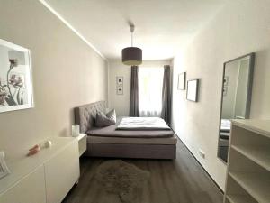 een kleine kamer met een bed en een spiegel bij Wohnung mit Loggia und Stellplatz am Wenigemarkt in Erfurt