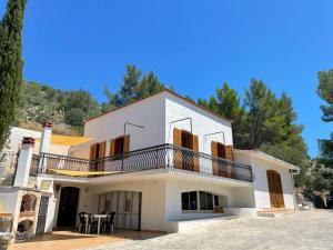 a large white house with a balcony and tables at Colori del Sud - Residence in Mattinata