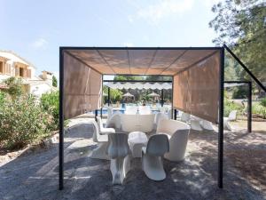 a table and chairs under a pavilion with a table at 8 bedrooms villa at Port de Pollenca 500 m away from the beach with private pool furnished garden and wifi in Port de Pollensa