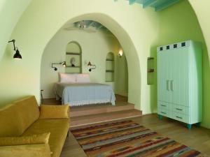a bedroom with a bed and a couch in a room at Aegean Garden Apartment in Kardhianí