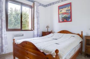 ル・グロー・ダグドにあるMaison de 3 chambres avec jardin clos a Agde a 1 km de la plageの窓付きのベッドルーム1室(木製ベッド1台付)