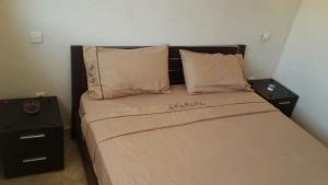 a bed with two pillows and two nightstands in a bedroom at One bedroom appartement with city view and terrace at Casablanca in Casablanca