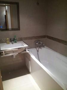 a bathroom with a white tub and a sink at One bedroom appartement with city view and terrace at Casablanca in Casablanca