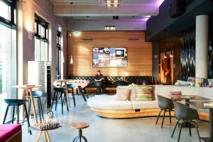 a lobby with a couch and a table and chairs at Moxy Frankfurt Eschborn in Eschborn