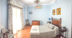 - une chambre bleue avec un lit et une chaise dans l'établissement 3 bedrooms house with city view balcony and wifi at Sevilla Penaflor, à Peñaflor
