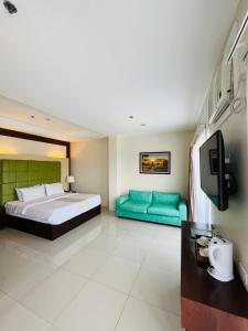 Sierra Hotel في دوماغيتي: غرفة نوم كبيرة مع سرير وأريكة