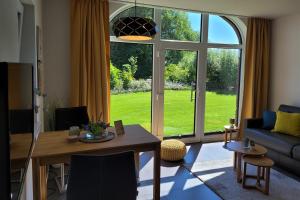 a living room with a table and a large window at FEWO Wiesenschlummerland Harriersand in Schwanewede