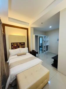 Schlafzimmer mit einem großen Bett mit einer Bank in der Unterkunft Sierra Hotel in Dumaguete