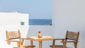 a table with two chairs and a table with a vase at Nove Milos Luxury by Estia in Pollonia